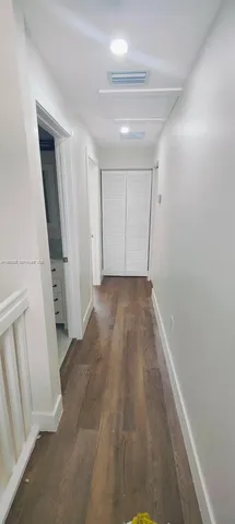 a view of hallway with wooden floor