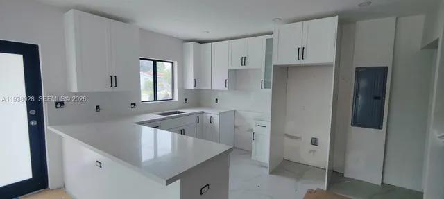 a kitchen with white cabinets and a sink