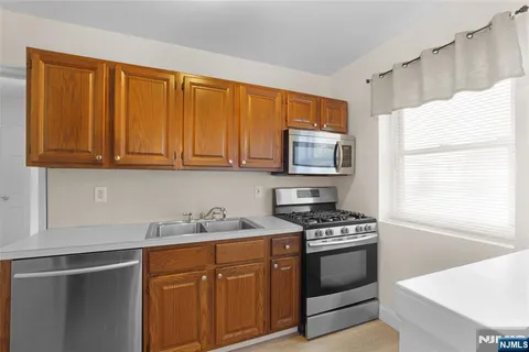 a kitchen with stainless steel appliances granite countertop a sink stove and microwave