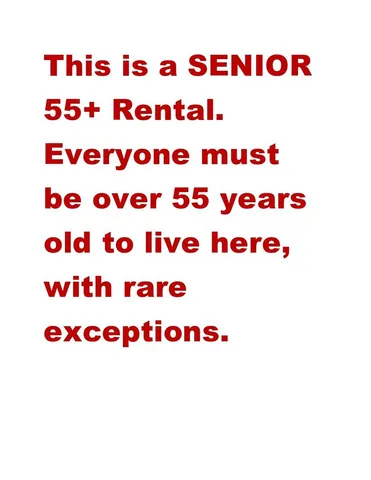 a view of a house with small yard plants and palm trees