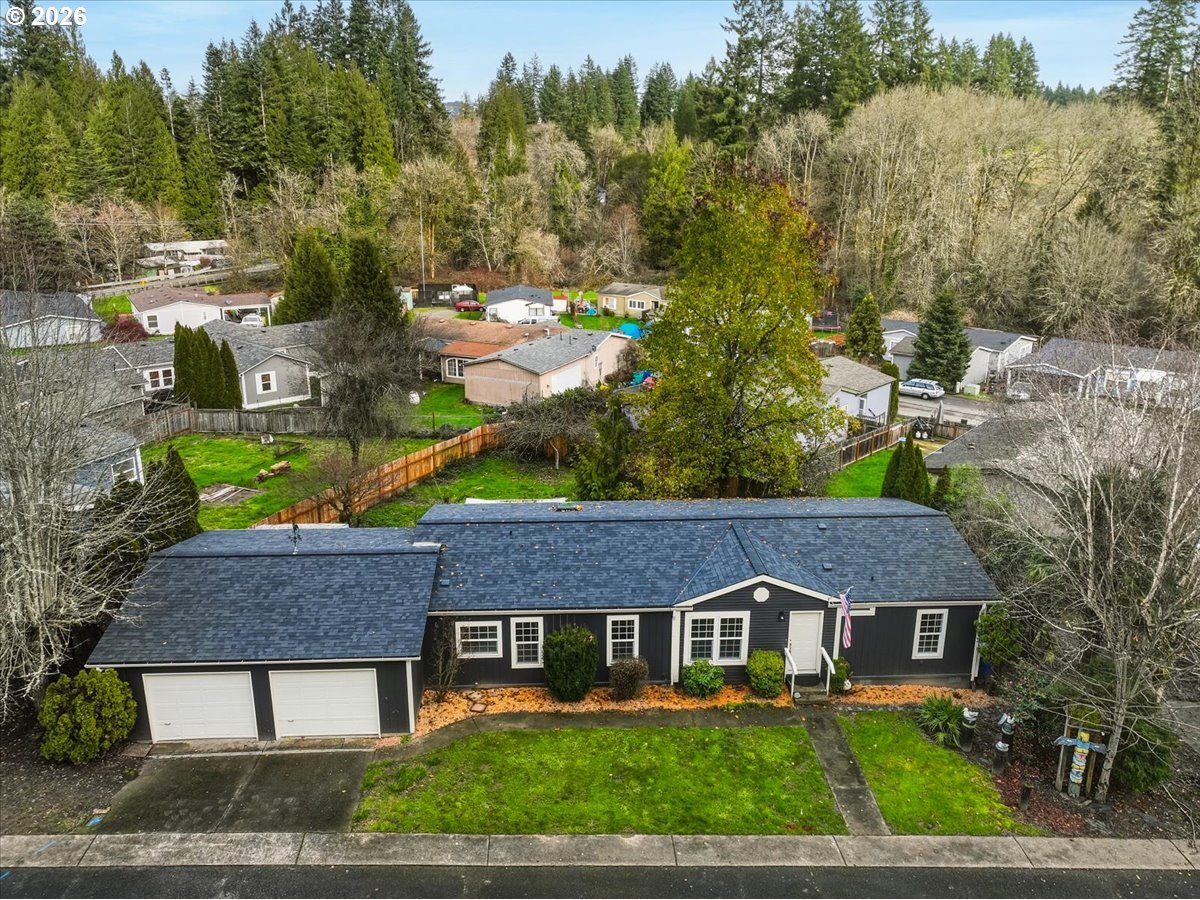 a aerial view of a house with a yard and large tree
