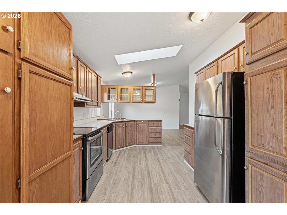 28 South Gee Creek Loop Ridgefield, WA 98642 - Photo 13 of 38 a kitchen with stainless steel appliances granite countertop a refrigerator and a stove top oven