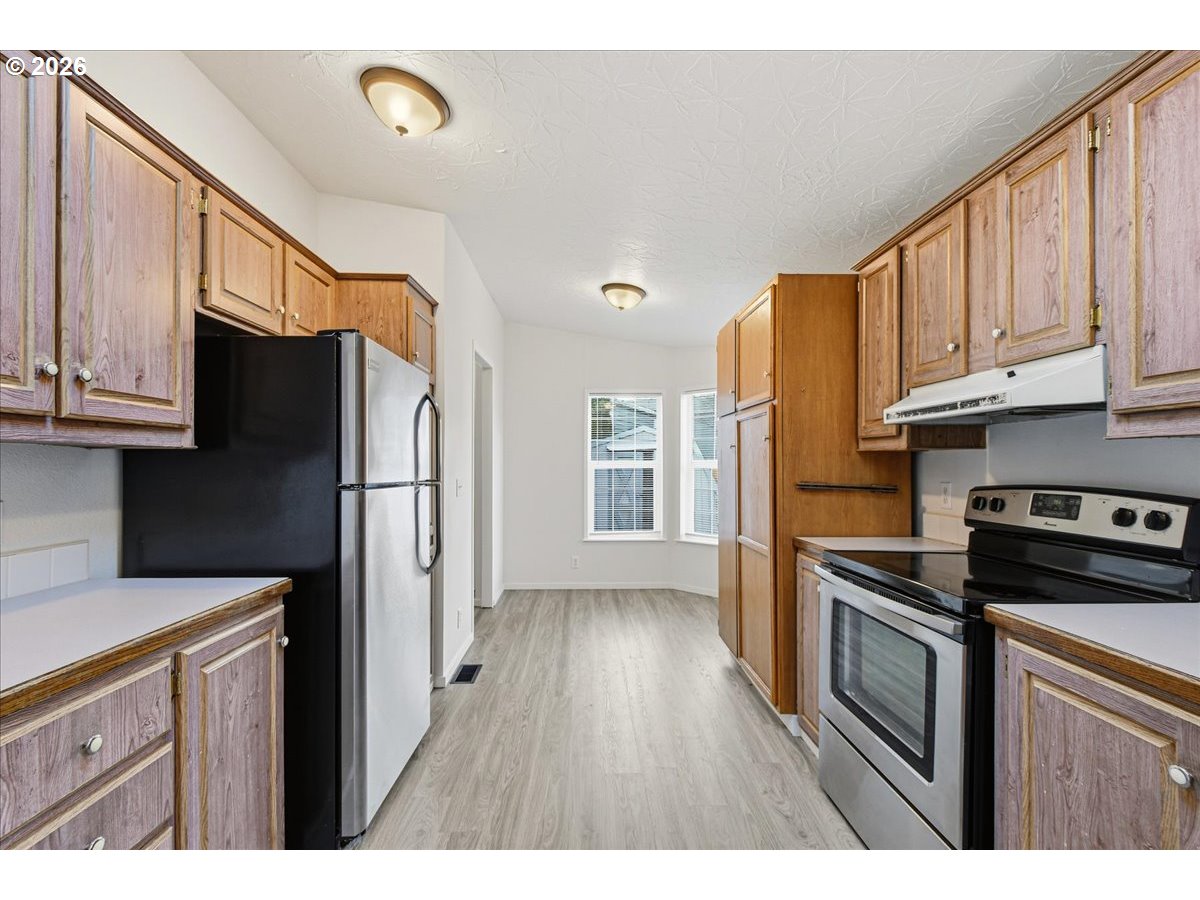 28 South Gee Creek Loop Ridgefield, WA 98642 - Photo 15 of 38 a kitchen with stainless steel appliances granite countertop a refrigerator sink and cabinets