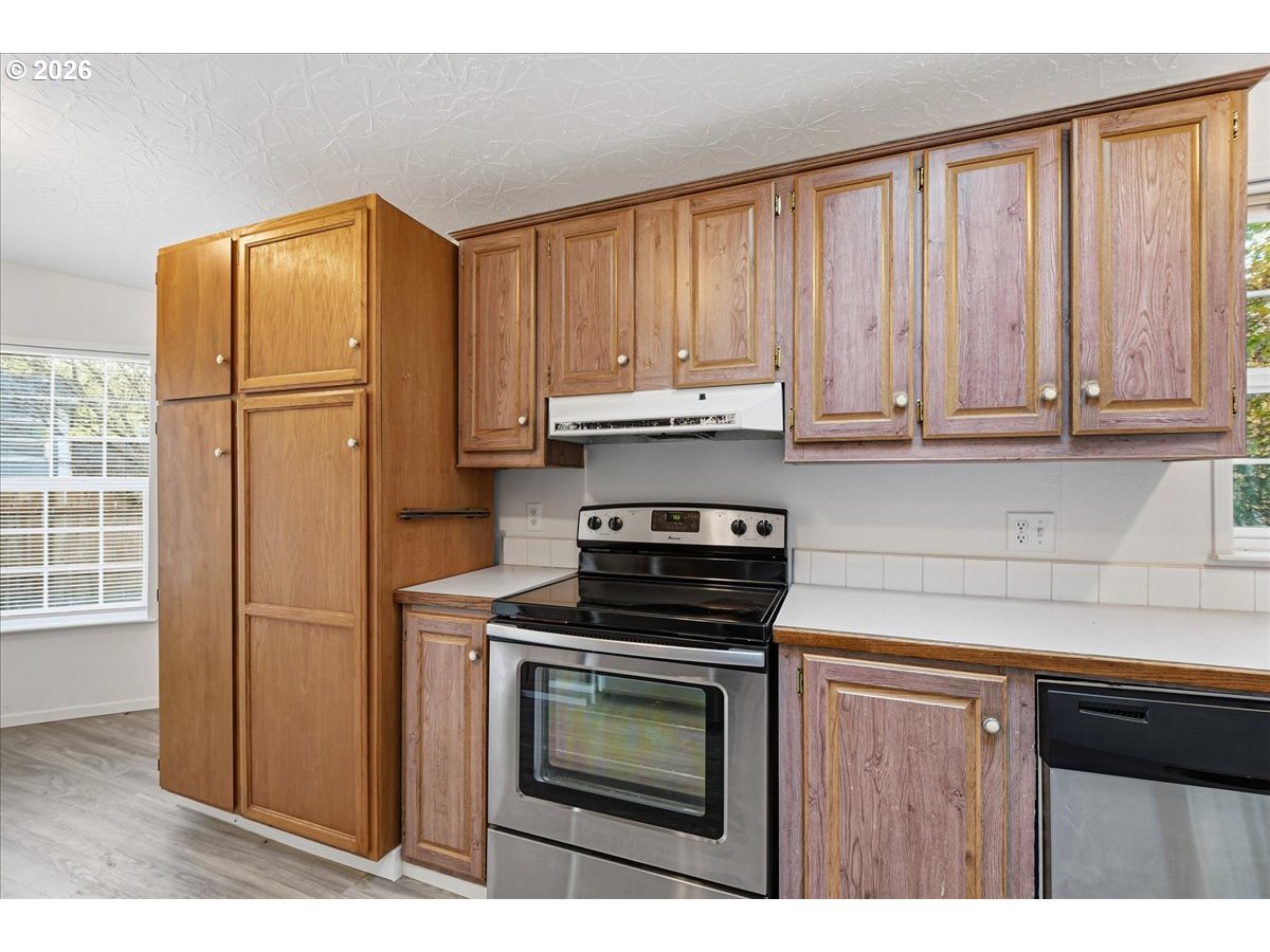 28 South Gee Creek Loop Ridgefield, WA 98642 - Photo 16 of 38 a kitchen with granite countertop a refrigerator stove and cabinets