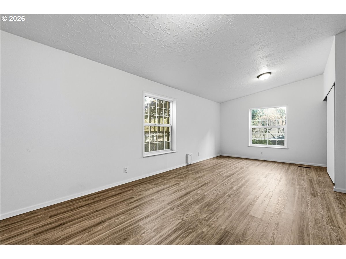 28 South Gee Creek Loop Ridgefield, WA 98642 - Photo 24 of 38 an empty room with wooden floor and windows