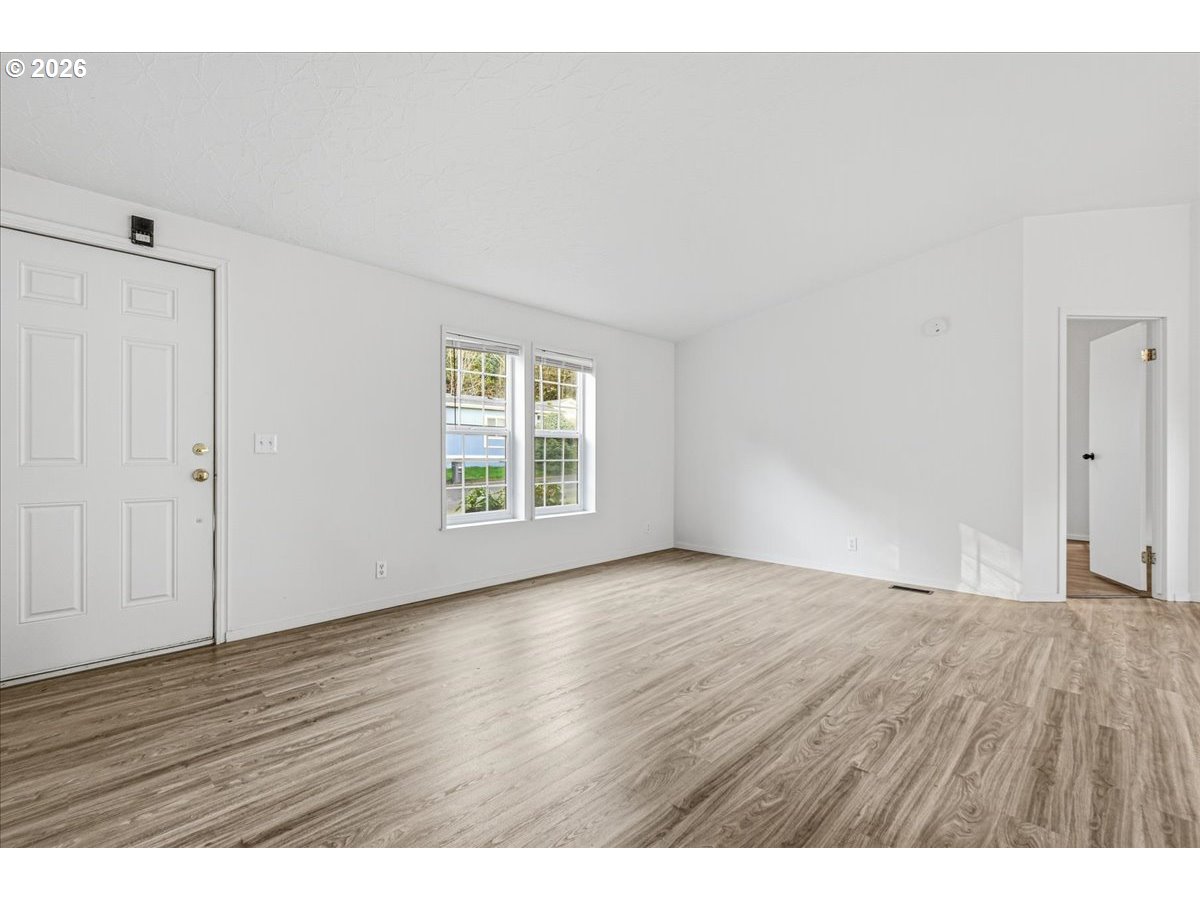 28 South Gee Creek Loop Ridgefield, WA 98642 - Photo 7 of 38 a view of an empty room with wooden floor and a window