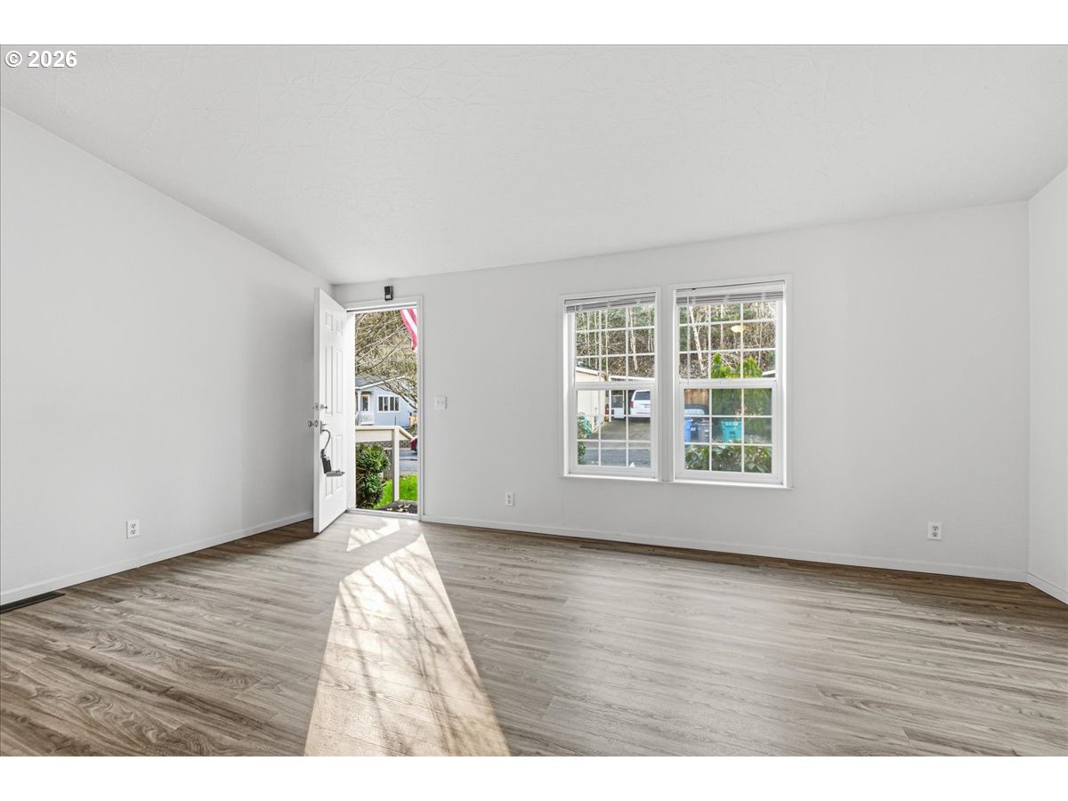 28 South Gee Creek Loop Ridgefield, WA 98642 - Photo 8 of 38 a view of an empty room with wooden floor and a window