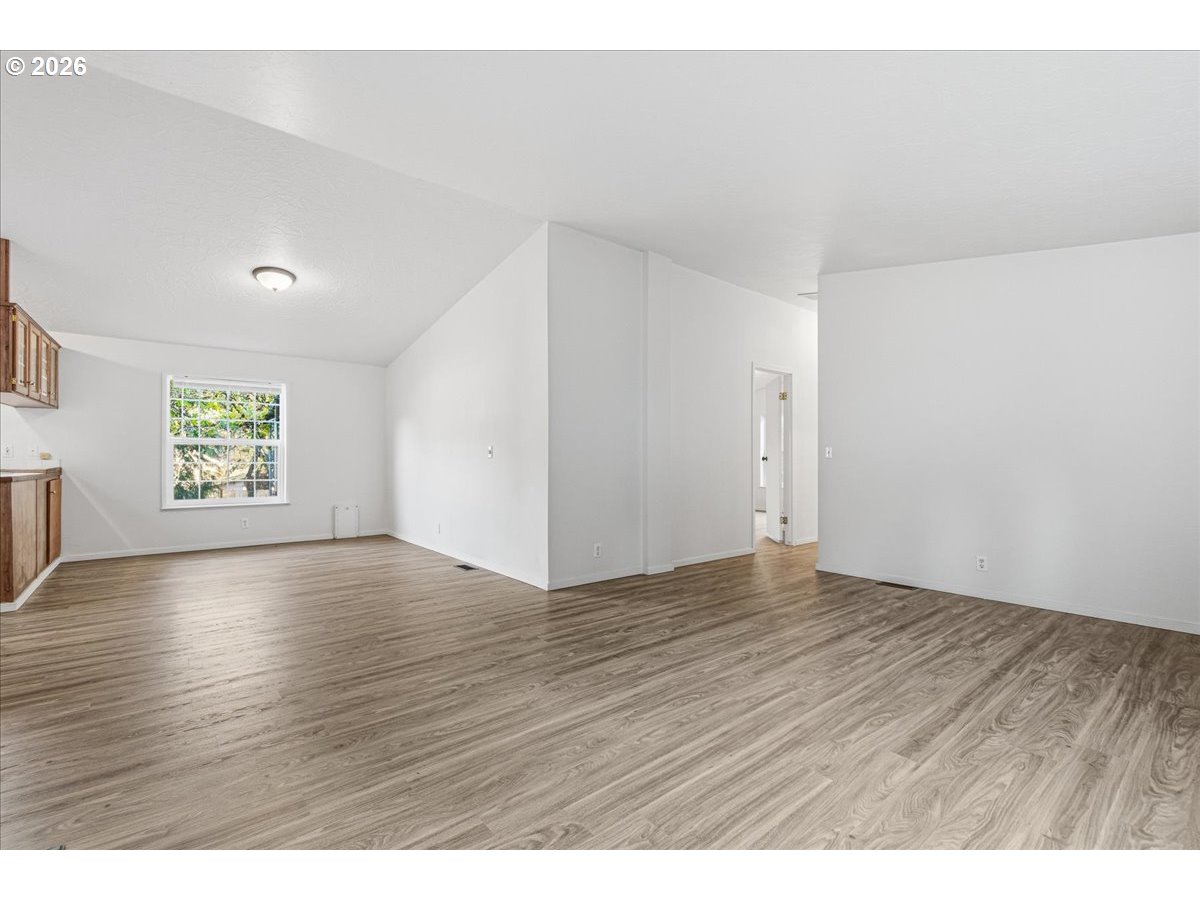 28 South Gee Creek Loop Ridgefield, WA 98642 - Photo 10 of 38 a view of an empty room with wooden floor and a window