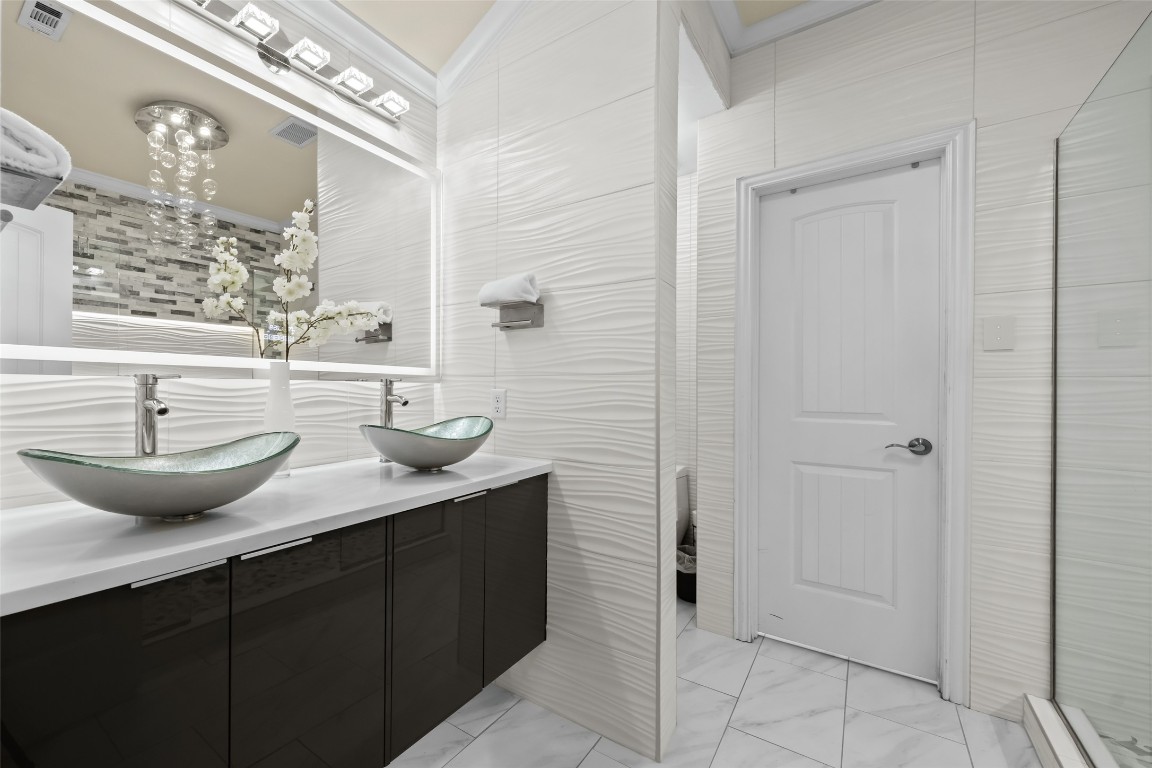 355 Evening Star Kyle, TX 78640 - Photo 12 of 21 Bathroom featuring double vanity, includes a wifi able mirror glass ornate dual bowls and a large walk in primary closet with plenty of custom cabinets.