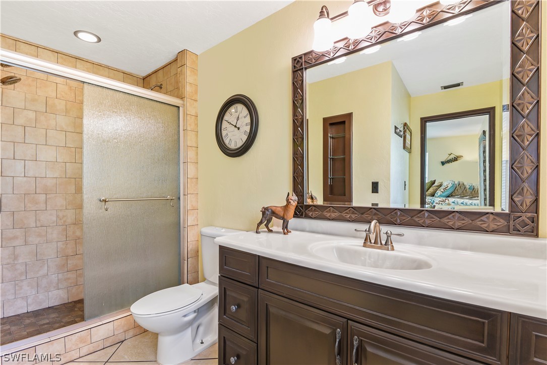 12478 Dolphin Road Bokeelia, FL 33922 - Photo 11 of 25 a bathroom with a sink mirror vanity and toilet