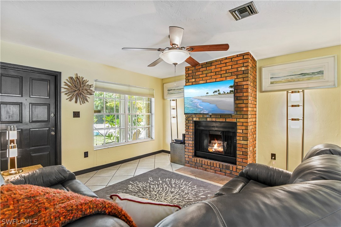 12478 Dolphin Road Bokeelia, FL 33922 - Photo 12 of 25 a living room with furniture a fireplace and a large window