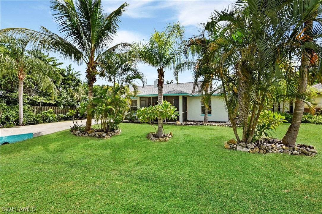 12478 Dolphin Road Bokeelia, FL 33922 - Photo 24 of 25 a view of an house with backyard and a tree