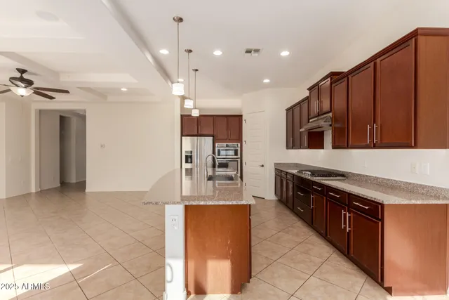 a kitchen with stainless steel appliances granite countertop a sink stove and refrigerator