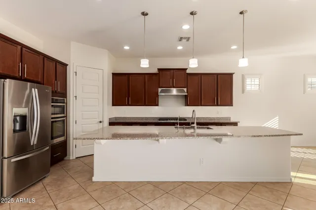 a kitchen with granite countertop a stove and a refrigerator