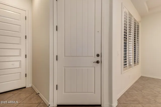 an empty room with white walls and fan