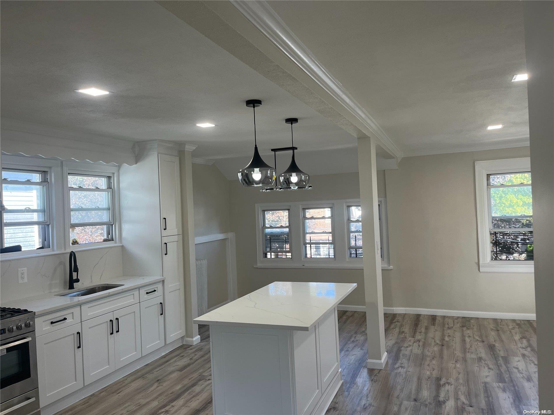 a kitchen with granite countertop a sink stove and cabinets
