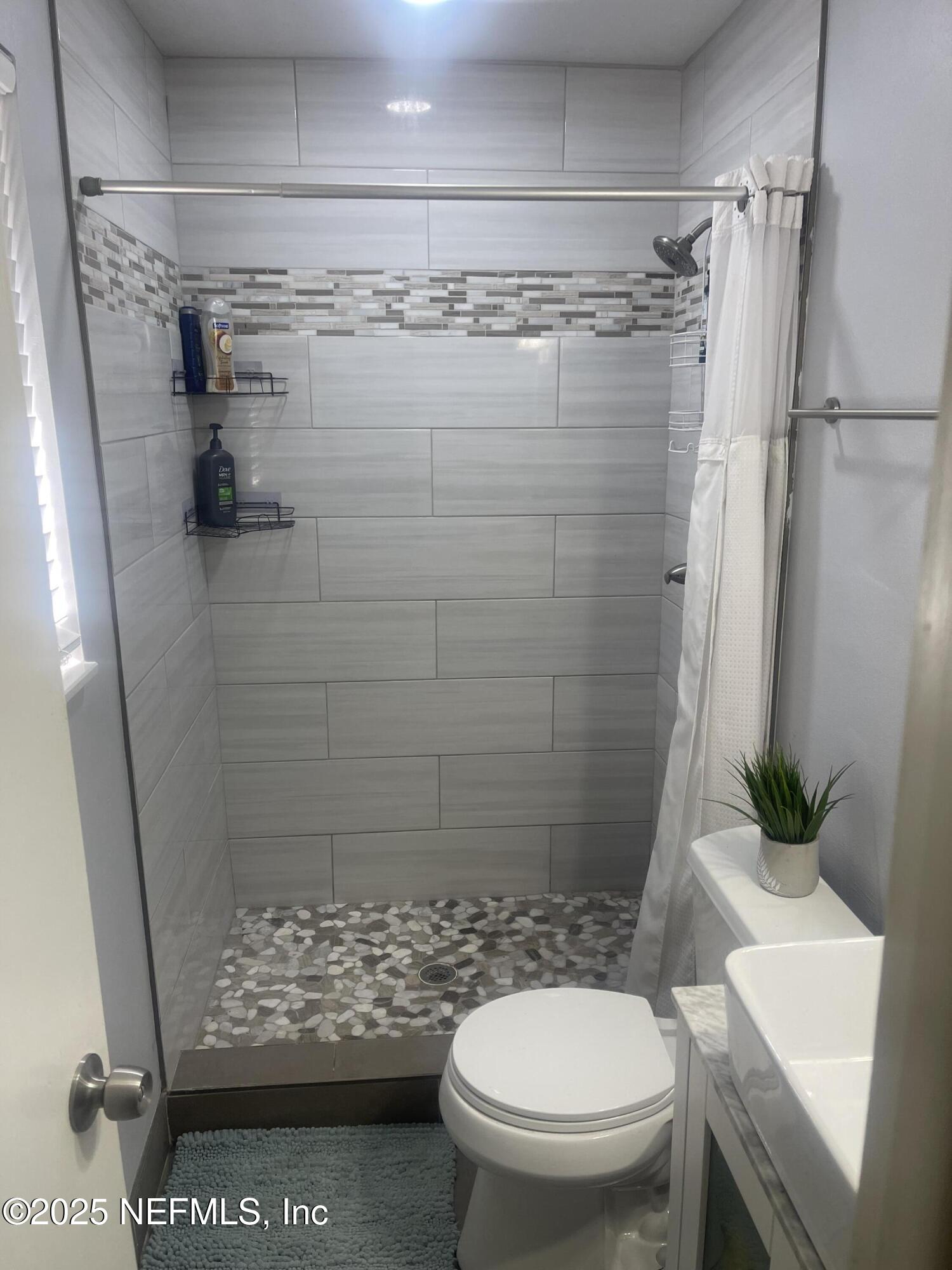 5203 Clarendon Road Jacksonville, FL 32205 - Photo 12 of 12 a bathroom with a shower and a toilet