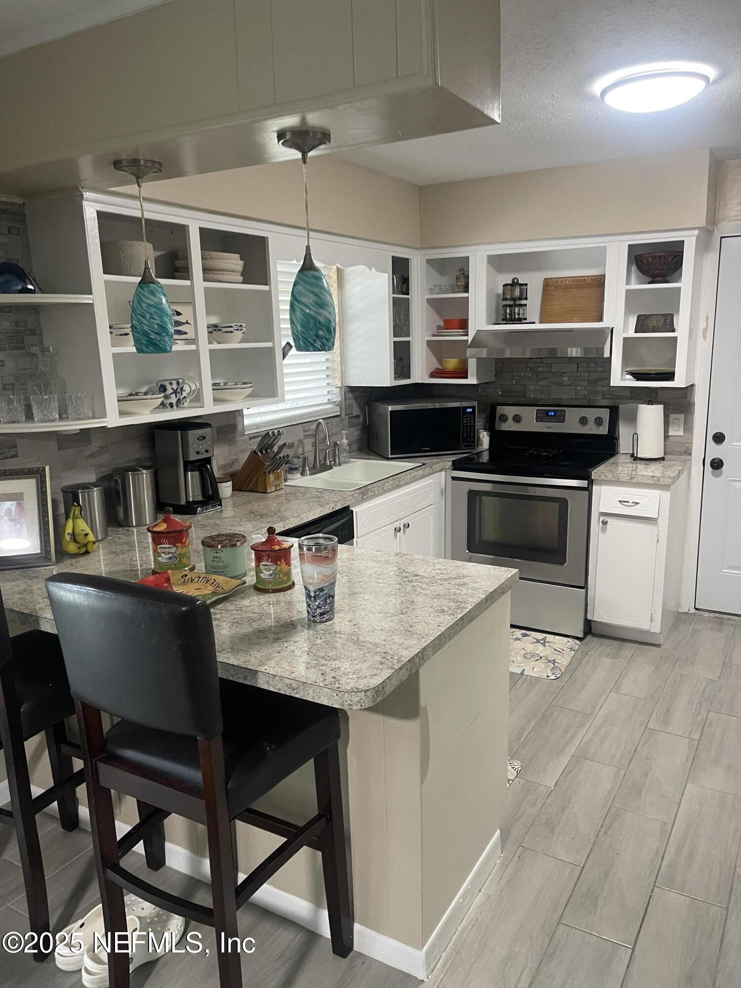 5203 Clarendon Road Jacksonville, FL 32205 - Photo 10 of 12 a kitchen with a table chairs microwave and cabinets