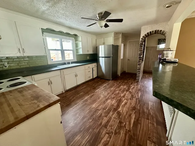 a kitchen with sink a counter top space stainless steel appliances and cabinets
