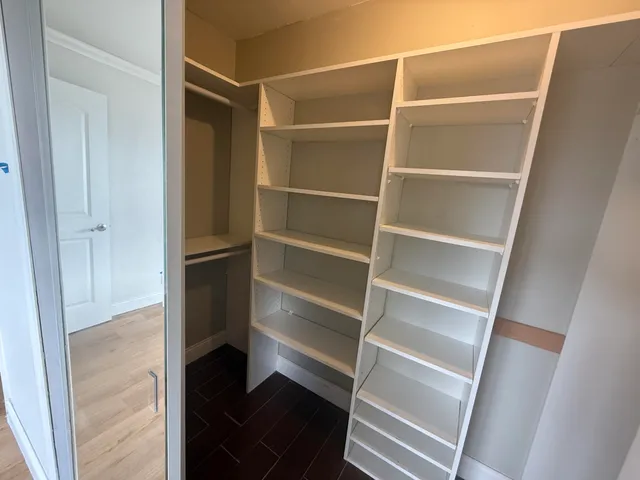 a view of walk in closet with empty racks