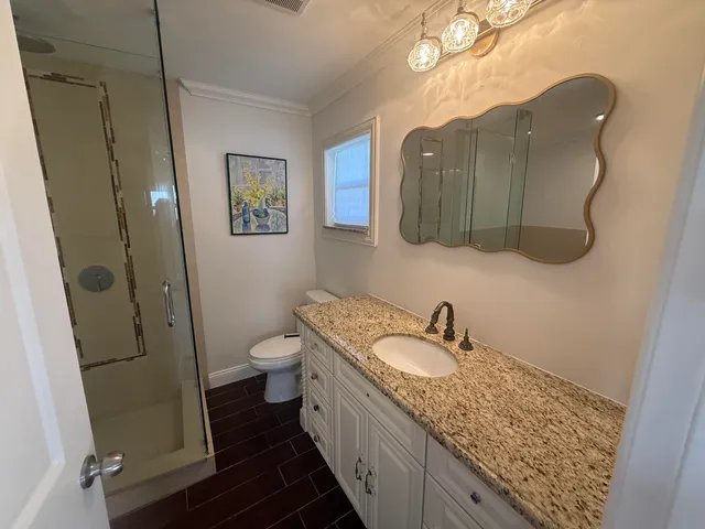 a bathroom with a granite countertop sink toilet and shower