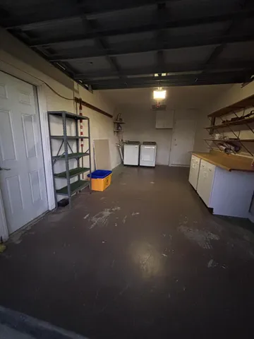 a view of an empty room with projector and a window