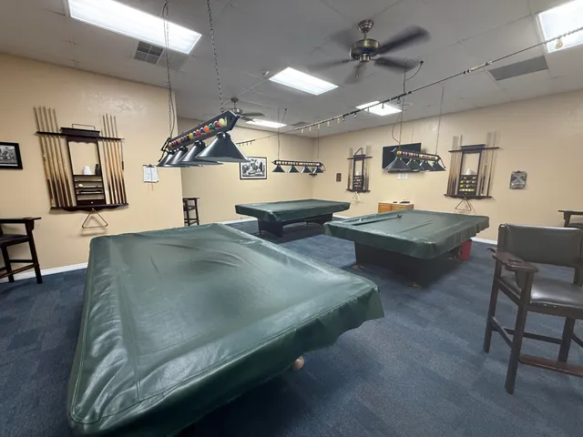 a living room with couches and kitchen view with wooden floor