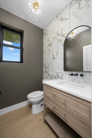 a bathroom with a sink a toilet and mirror