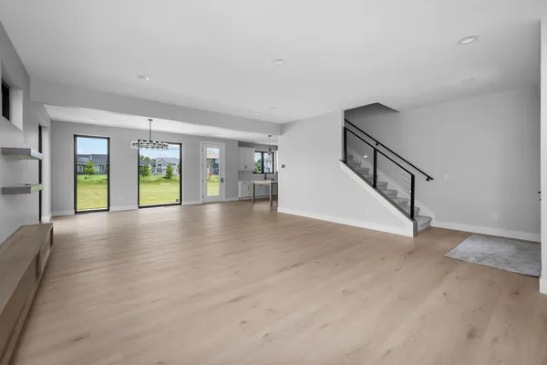 a view of a livingroom with furniture wooden floor windows and a chandelier
