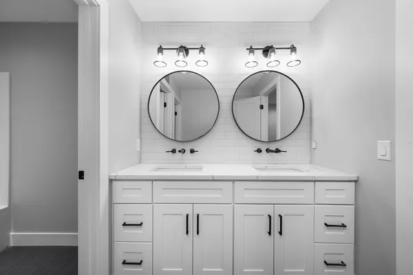 a bathroom with a double vanity sink mirror and shower