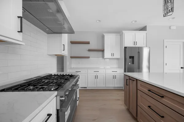 a kitchen with stainless steel appliances a sink stove and refrigerator