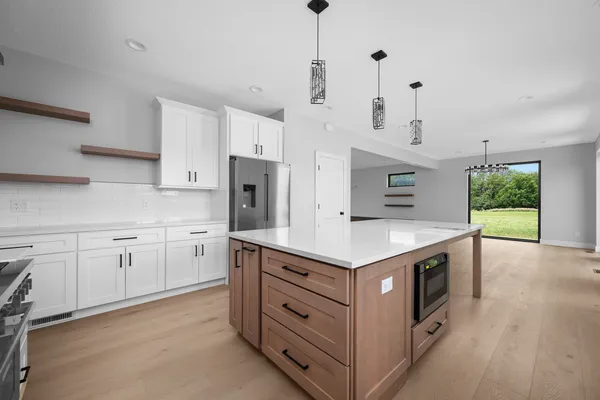 a kitchen that has a lot of cabinets in it and stainless steel appliances
