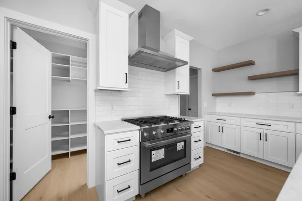 a kitchen with cabinets appliances and a wooden floor