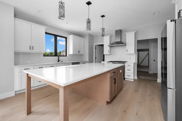 a kitchen with stainless steel appliances a dining table chairs sink and cabinets
