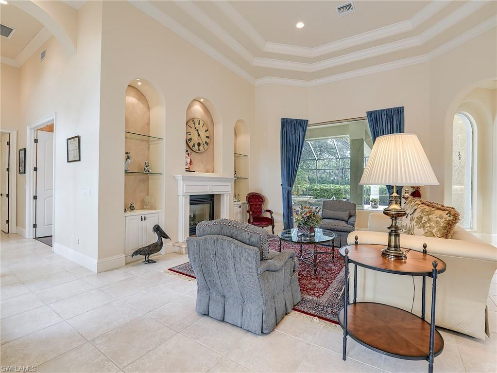 10128 Idle Pine Lane Estero, FL 34135 - Photo 11 of 50 a living room with furniture a fireplace and a large window