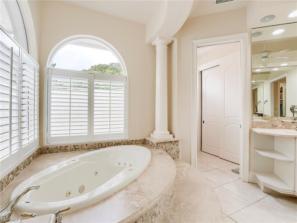 10128 Idle Pine Lane Estero, FL 34135 - Photo 19 of 50 a bathroom with a tub a sink and a large window