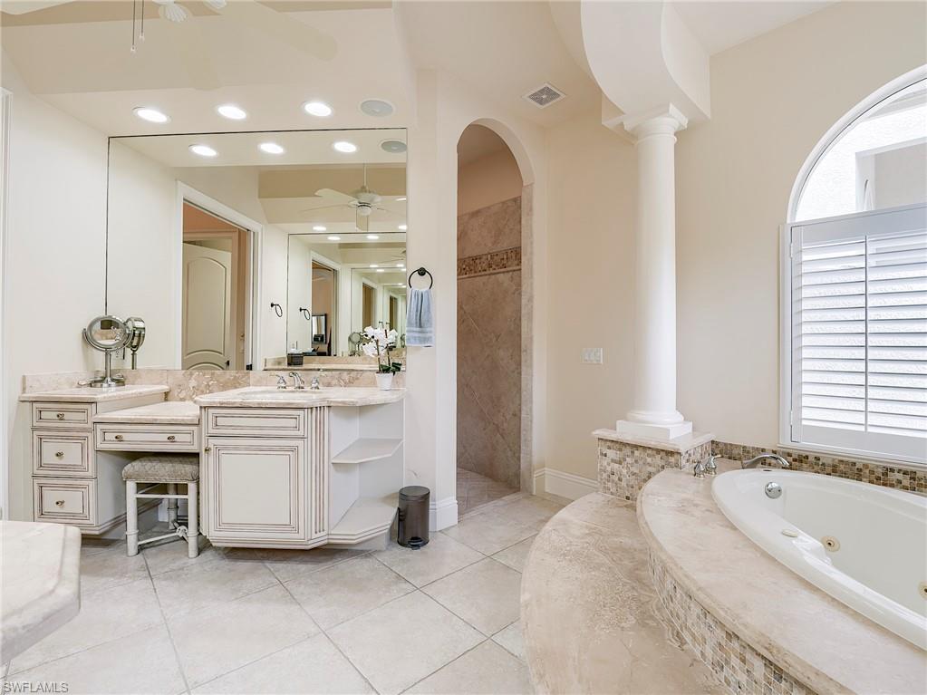 10128 Idle Pine Lane Estero, FL 34135 - Photo 20 of 50 a spacious bathroom with a granite countertop sink a mirror and a bathtub