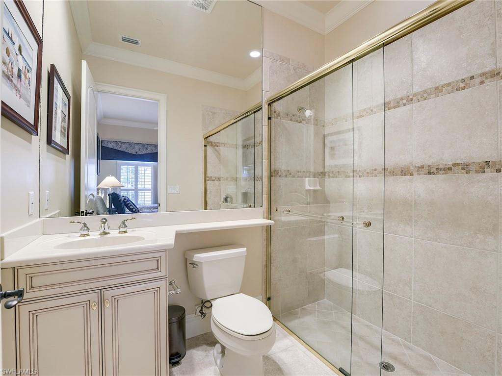 10128 Idle Pine Lane Estero, FL 34135 - Photo 23 of 50 a bathroom with a sink toilet vanity and shower