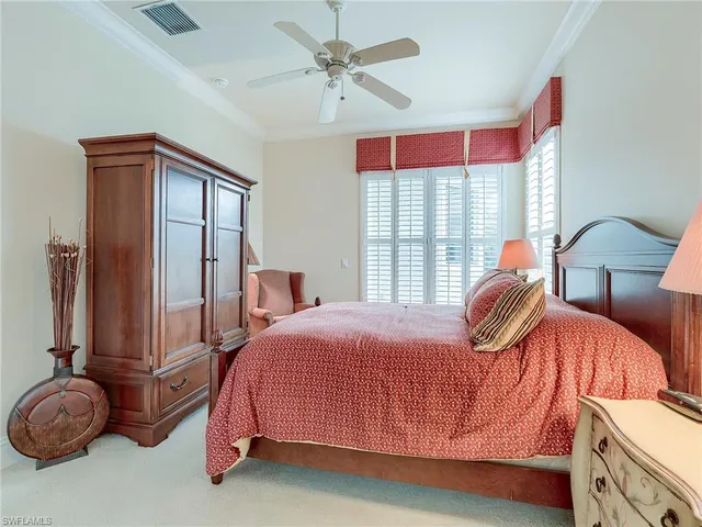 a bedroom with a bed and dresser with mirror