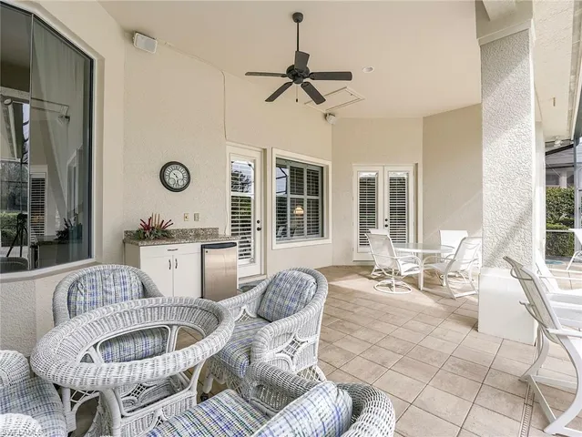 a living room with patio furniture and a large window