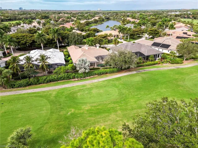 an aerial view of residential houses with outdoor space and trees