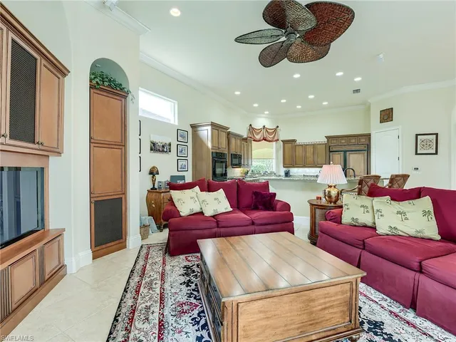 a living room with furniture kitchen view and a chandelier