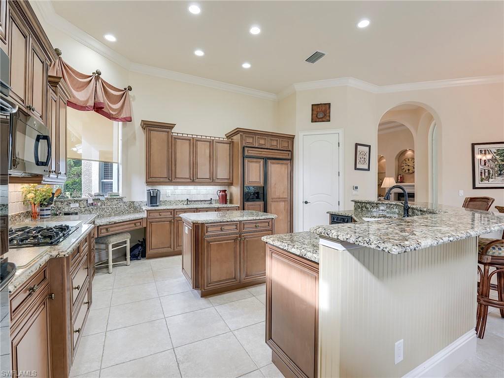 10128 Idle Pine Lane Estero, FL 34135 - Photo 7 of 50 a large kitchen with stainless steel appliances granite countertop a stove and a sink