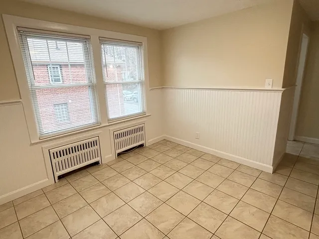 an empty room with a window and a kitchen