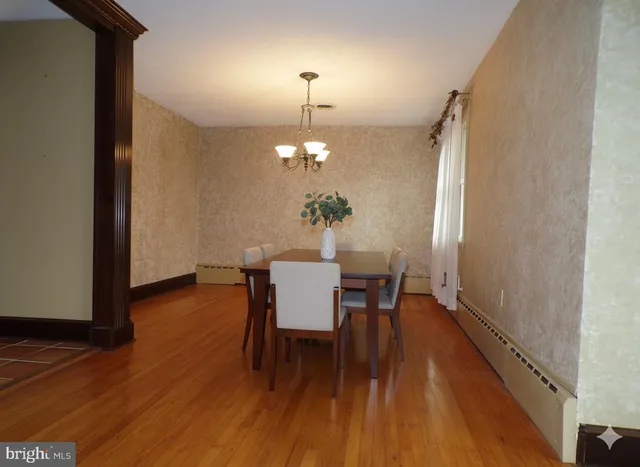 a dining room with furniture a chandelier and wooden floor