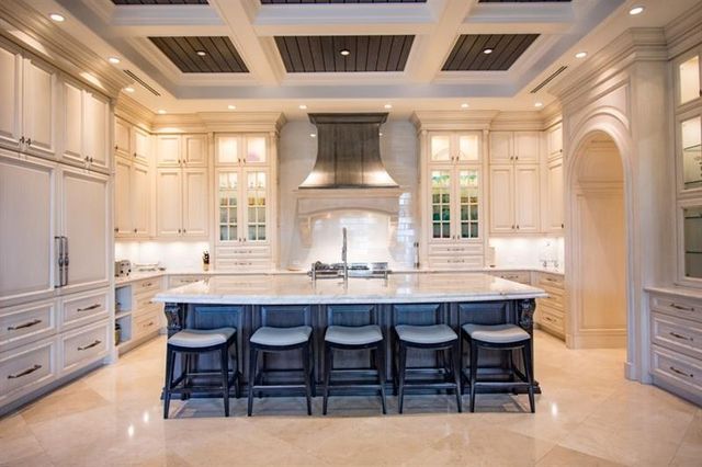 a dining hall with stainless steel appliances kitchen island granite countertop a table and chairs in it