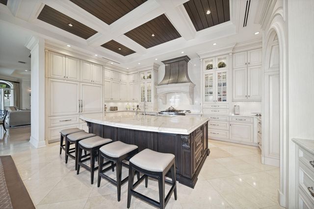 a kitchen with a sink chairs and white appliances