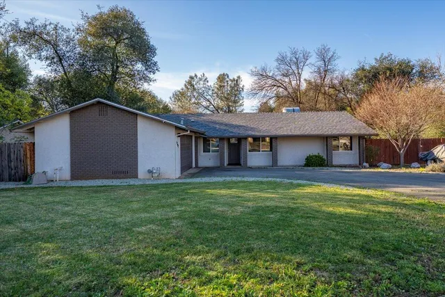 a view of a yard in front of a house with large tree