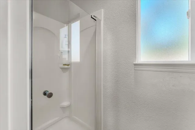 a bathroom with a glass shower door
