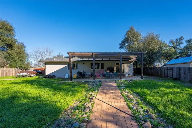 a view of a house with backyard and sitting area